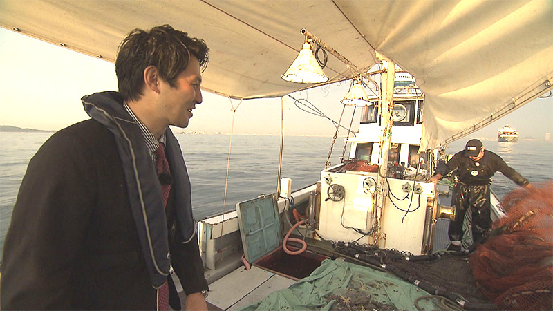 漁船に乗っている長岡ANと漁師