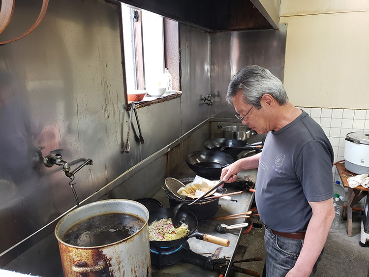 ちゃんぽんを作る店主の川嶋友文さん。手前に見える寸胴が、旨味を重ねた鶏ガラスープ