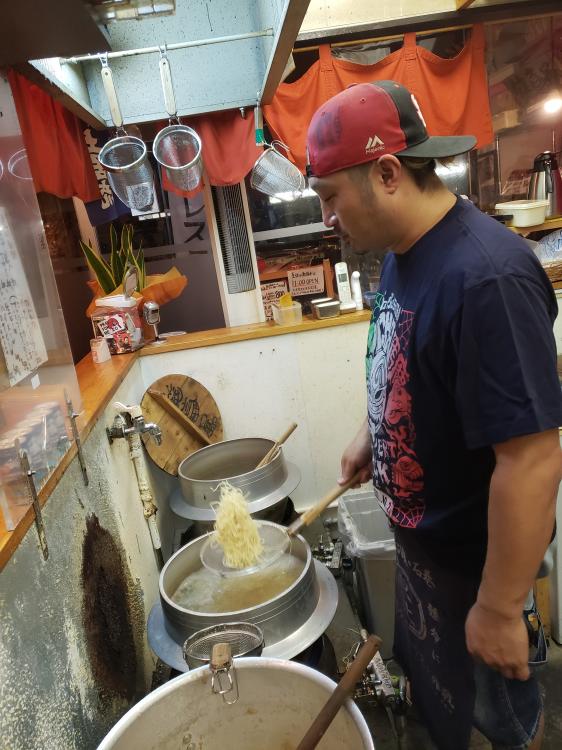 店主の河野友正さん。羽釜で麺を泳がせて湯切り