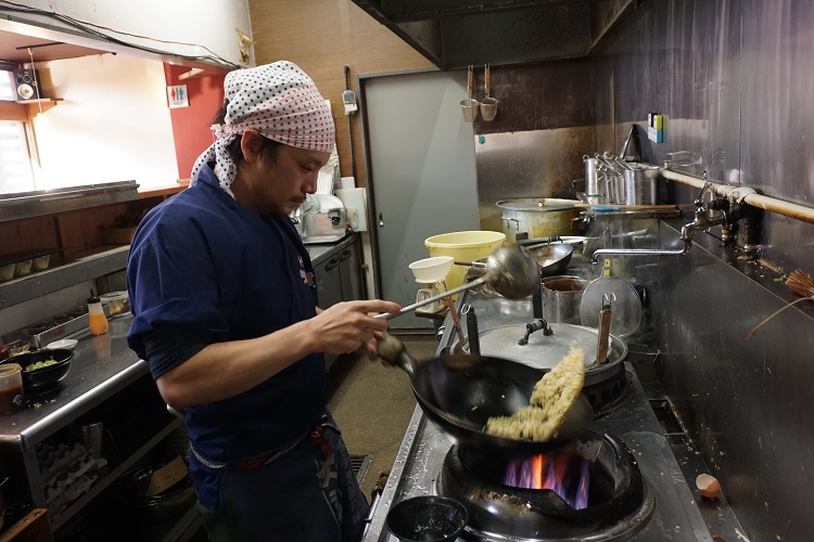 店主の西原哲平さん。味噌ラーメンに合うチャーハンを徹底追及。熟練の鍋さばきが旨さの要。米の炊き方も工夫している