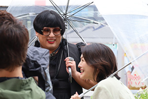 傘を差しながら談笑するYOKOとREIKO